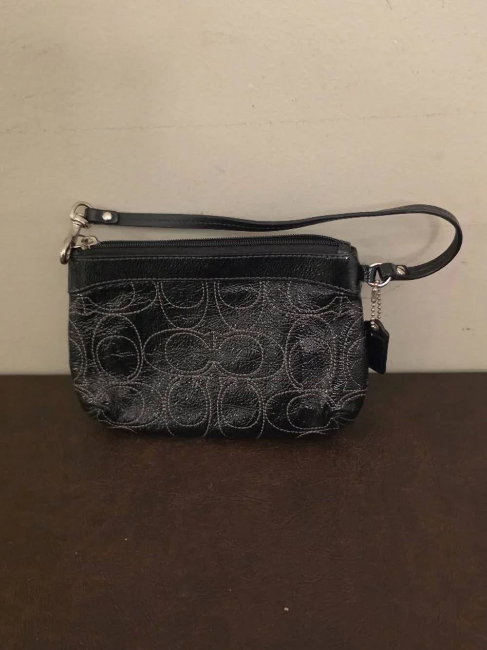 The Coach Signature Stitched Patent Leather Wristlet in black silver